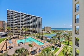 A hotel with multiple floors, a swimming pool, and palm trees. - Saida Iv Condo Unit #507 2 Bedroom Condo by RedAwning (South Padre Island)