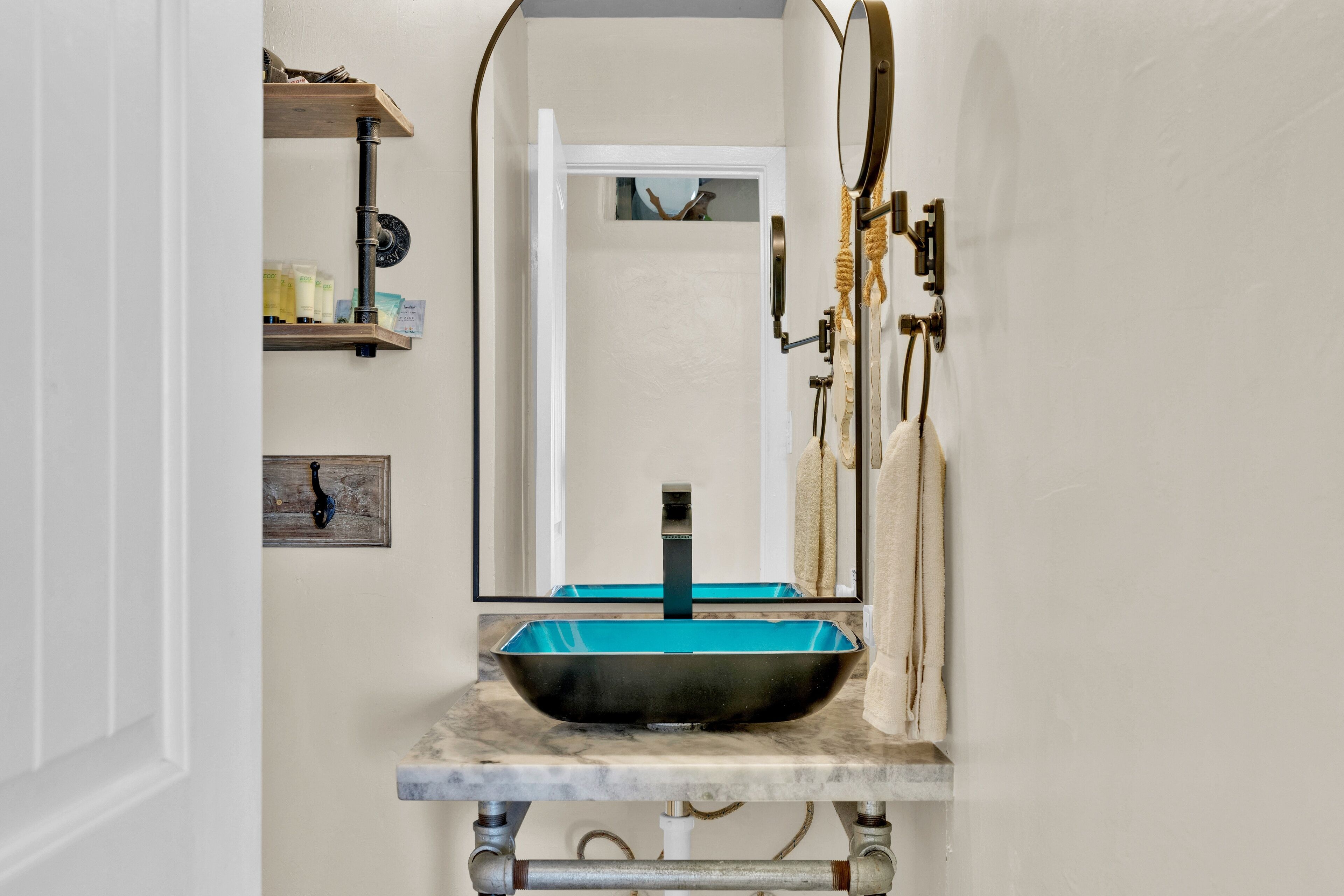 Un bagno con un lavabo moderno, uno specchio e un porta asciugamani.