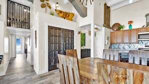 Une cuisine spacieuse avec des meubles en bois, une grande table à manger et une vue sur le salon.