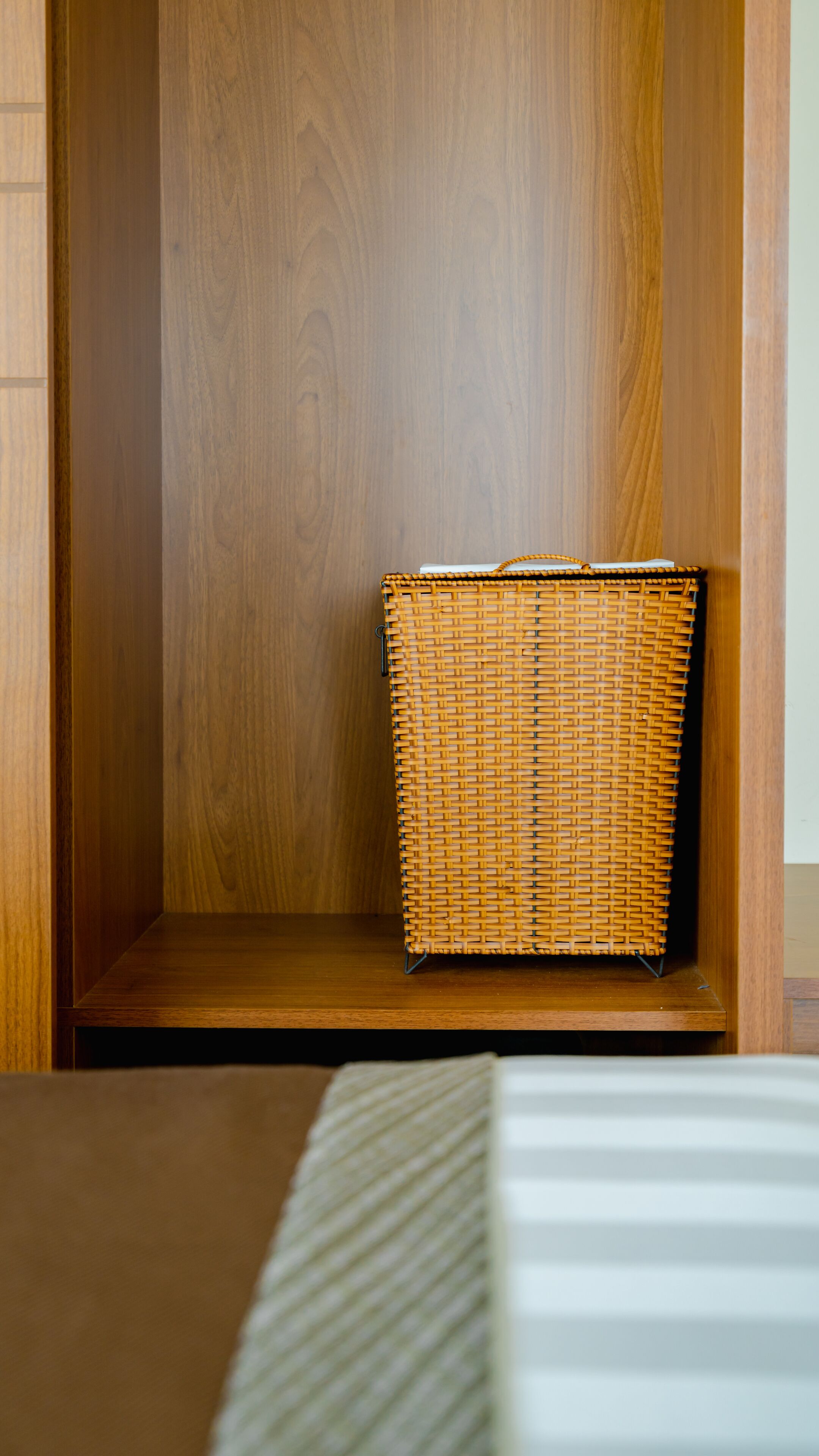 A wooden cabinet with a wicker basket inside.