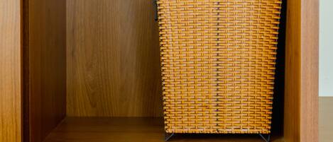 A wooden cabinet with a wicker basket inside.