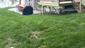 Una casa de dos pisos con un porche, un patio cubierto y vista a un lago.