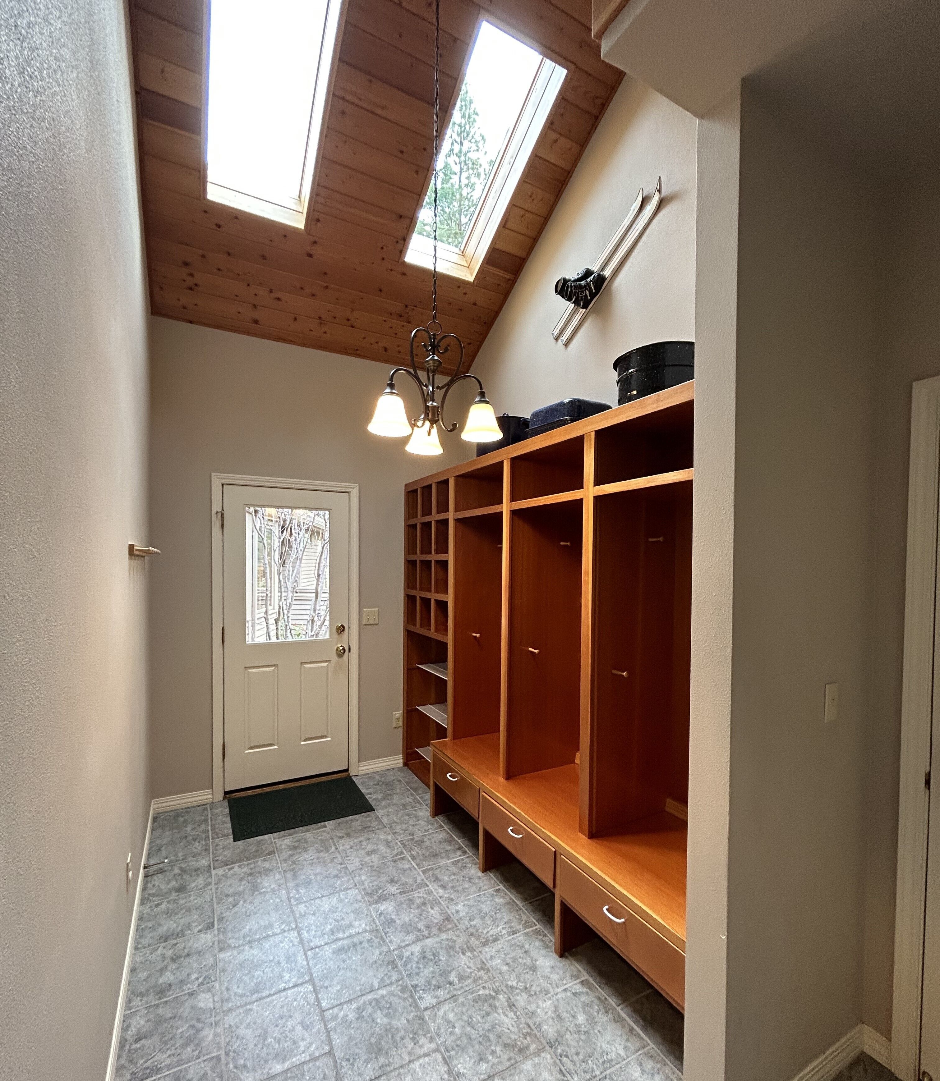 Un dressing avec des étagères en bois et un puits de lumière.