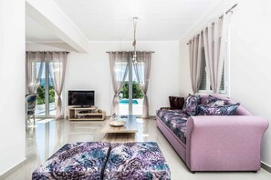 Un salon moderne avec un téléviseur à écran plat, un canapé et une table basse.