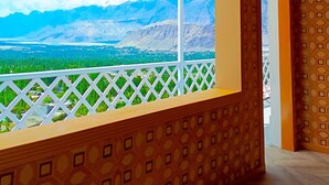 A room with a balcony overlooking a mountainous landscape, patterned walls, and a ceiling with geometric designs. - Mountain Lodge Resort (Skardu)