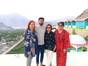 A group of people standing on a terrace with a mountainous landscape in the background. - Mountain Lodge Resort (Skardu)