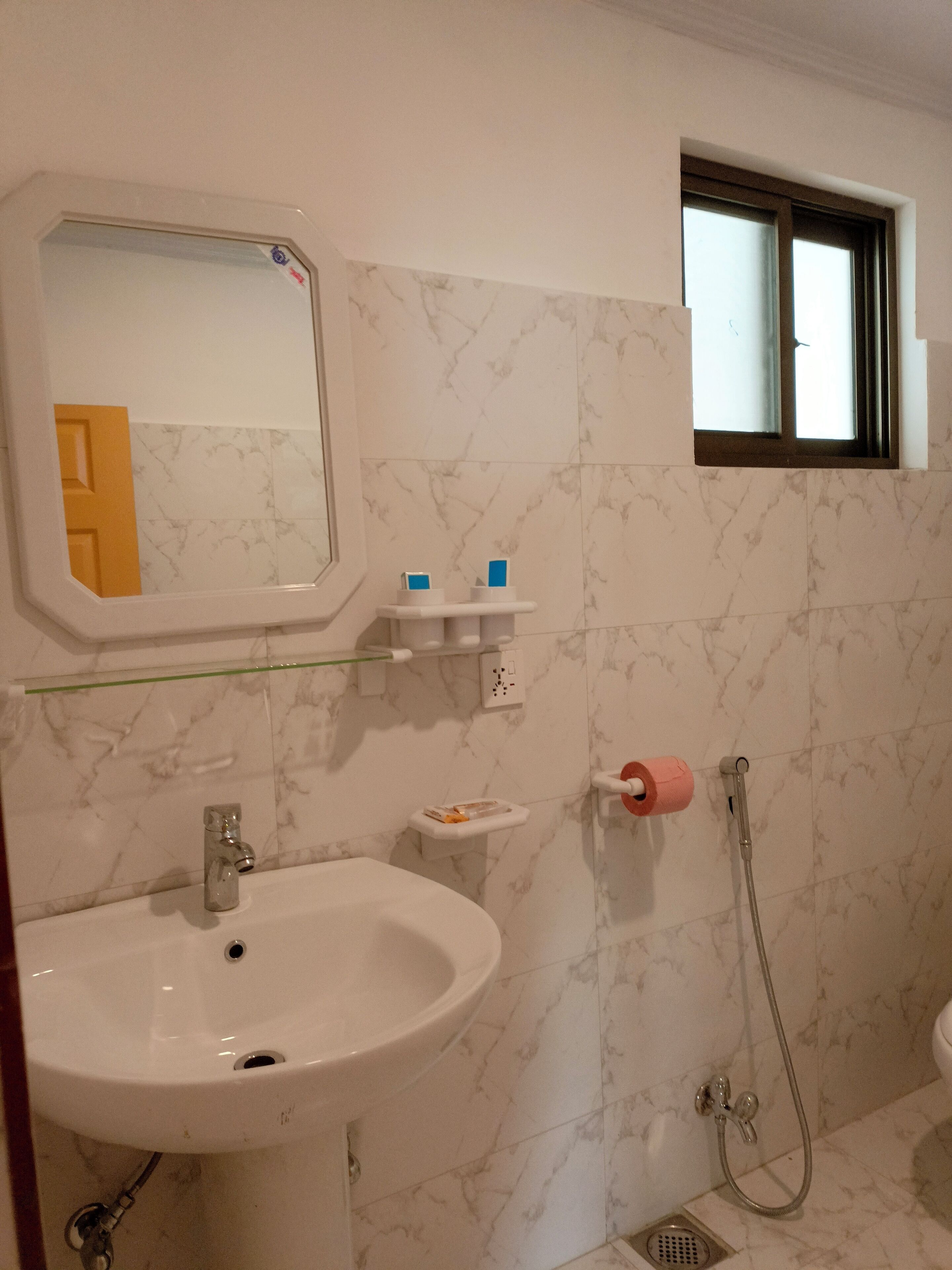 A bathroom with a sink, mirror, and shower.