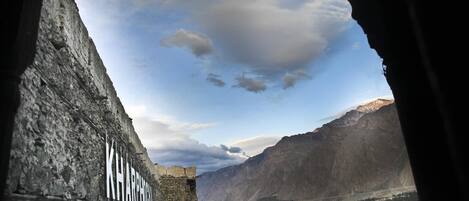 Vista a través de una abertura en una cueva, con una pared de piedra que dice 'KARAGH'.