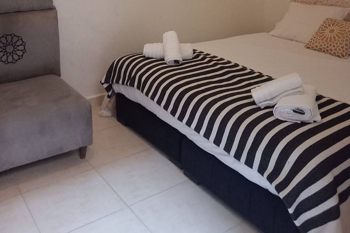A hotel room with a bed, a sofa, and a small table.
