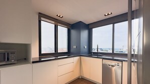 Eine moderne Küche mit Geschirrspüler, Mikrowelle und Fenster mit Blick auf die Stadt.