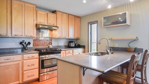 Una cocina moderna con armarios de madera, electrodomésticos de acero inoxidable y encimera de granito.