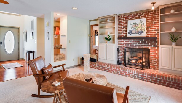 Una sala de estar con chimenea de ladrillo, sillones de cuero y una mesa de centro.