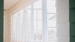 A hallway with white paneled walls and a large window with multiple panes. - Casa Amarta Canggu - Boutique Loft & Detox Spa (Canggu)