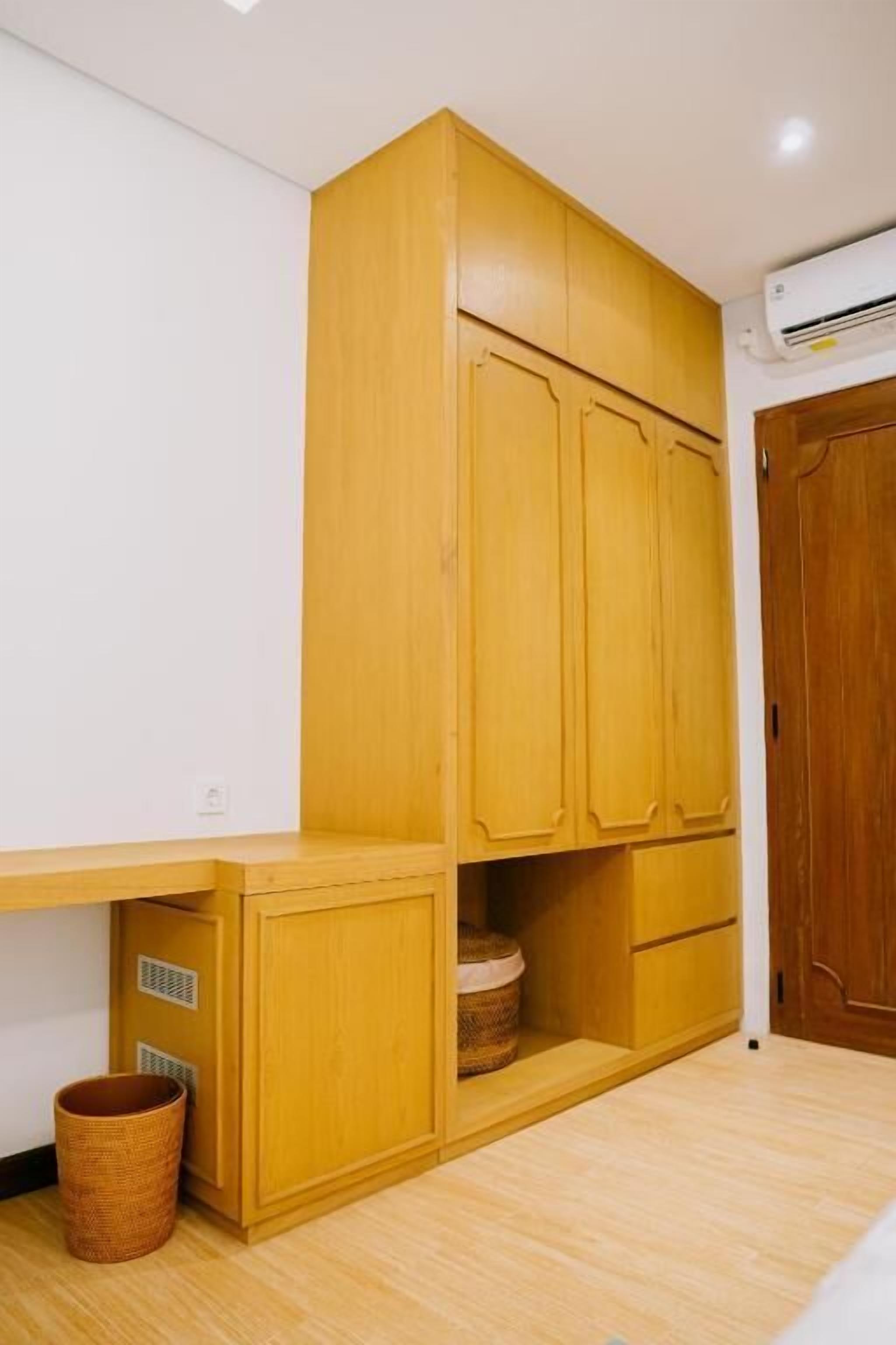 Ein Zimmer mit Holzschränken, einem Korbwannen und Holzboden.