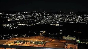A nighttime view of a cityscape with a lit-up building in the foreground. - Al-jabal castle Hotel - Ajloun (Ajloun)