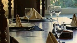 A dining table set with plates, napkins, and wine glasses. - Al-jabal castle Hotel - Ajloun (Ajloun)