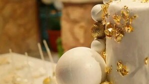 A close-up of a cake with white icing and gold decorations. - Al-jabal castle Hotel - Ajloun (Ajloun)