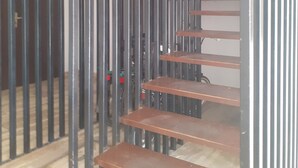 Un escalier avec des rampes en métal et des marches en bois.