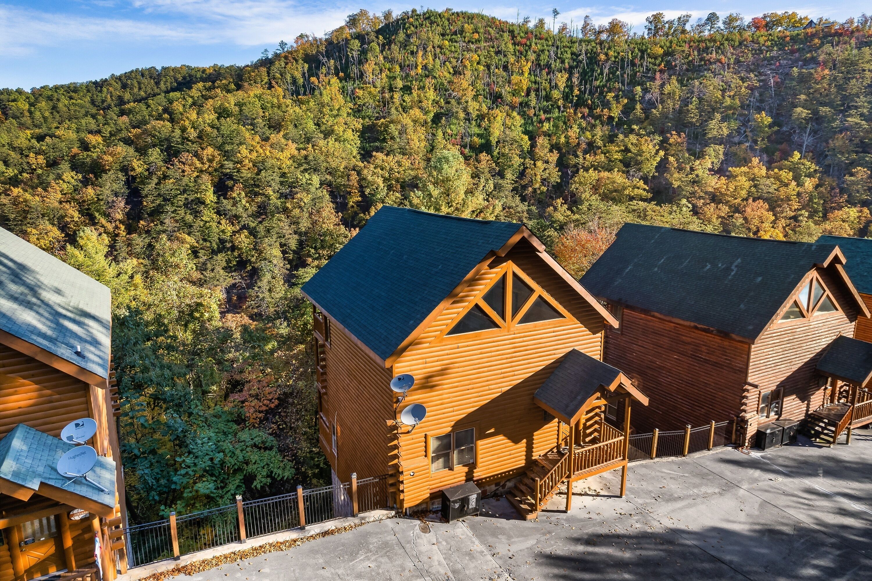 A wooden cabin with a steep roof, a satellite dish, and a staircase leading to the entrance.