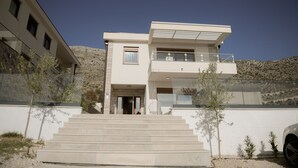 A modern two-story building with a flat roof, large windows, and a balcony. - Villa Dubrovnik Heights – Private pool and jacuzzi with sea view (Ivanica)