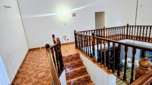 A staircase with wooden railings and patterned floor tiles. - Apartment 379 Hudson Avenue (Montego Bay)