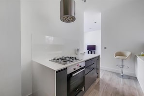 Appartement | Cuisine privée | Réfrigérateur, four à micro-ondes, un four, surface de cuisson