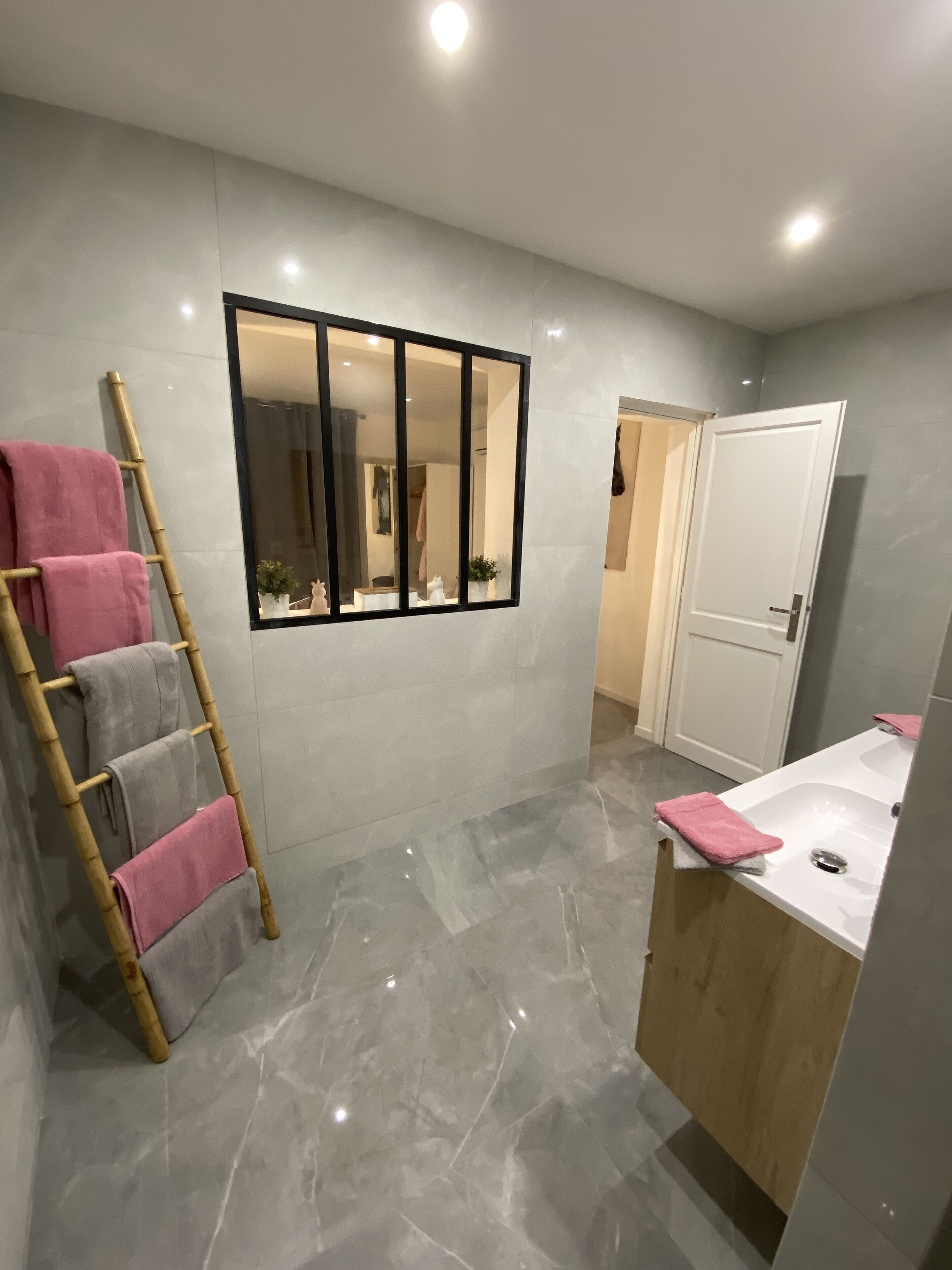 A bathroom with a mirror, a sink, and a towel rack.