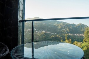 Vista desde una ventana con vistas a un valle con edificios y colinas.