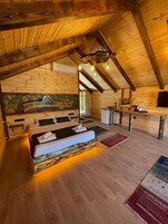 Un interior de madera con una cama, un escritorio y un televisor.