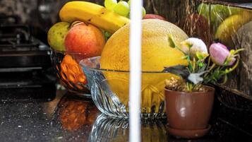 A kitchen counter with fruits and a potted plant.
