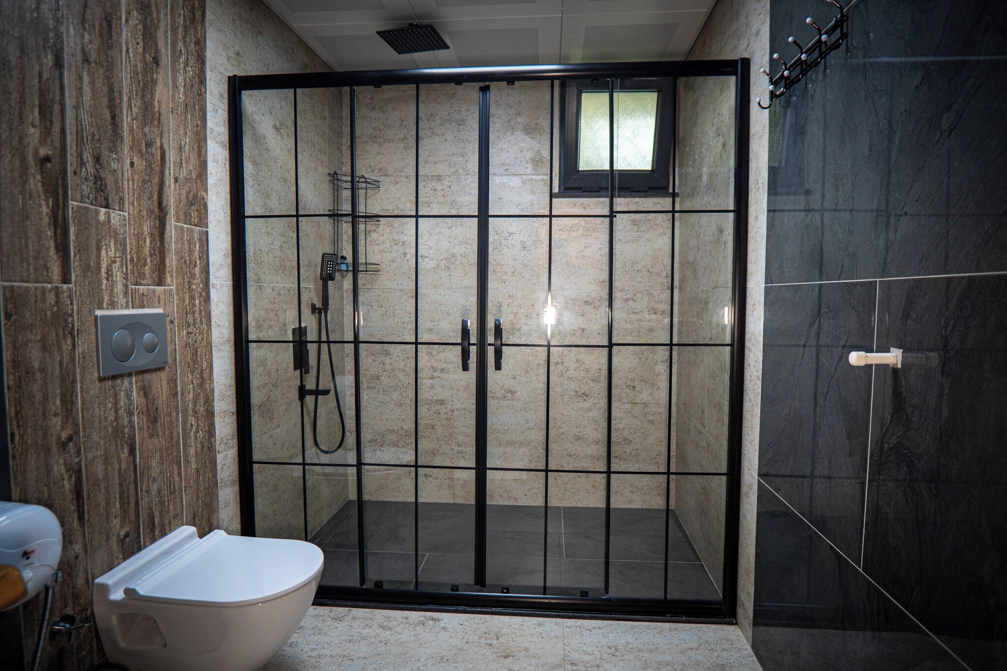 Une salle de bain moderne avec une douche, des toilettes et un porte-serviettes.
