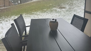 A dining table with chairs and a potted plant in a covered outdoor area. - Stressless Hotelapparat Inklusive Aktivcard Bayerischer Wald (Sankt Englmar)