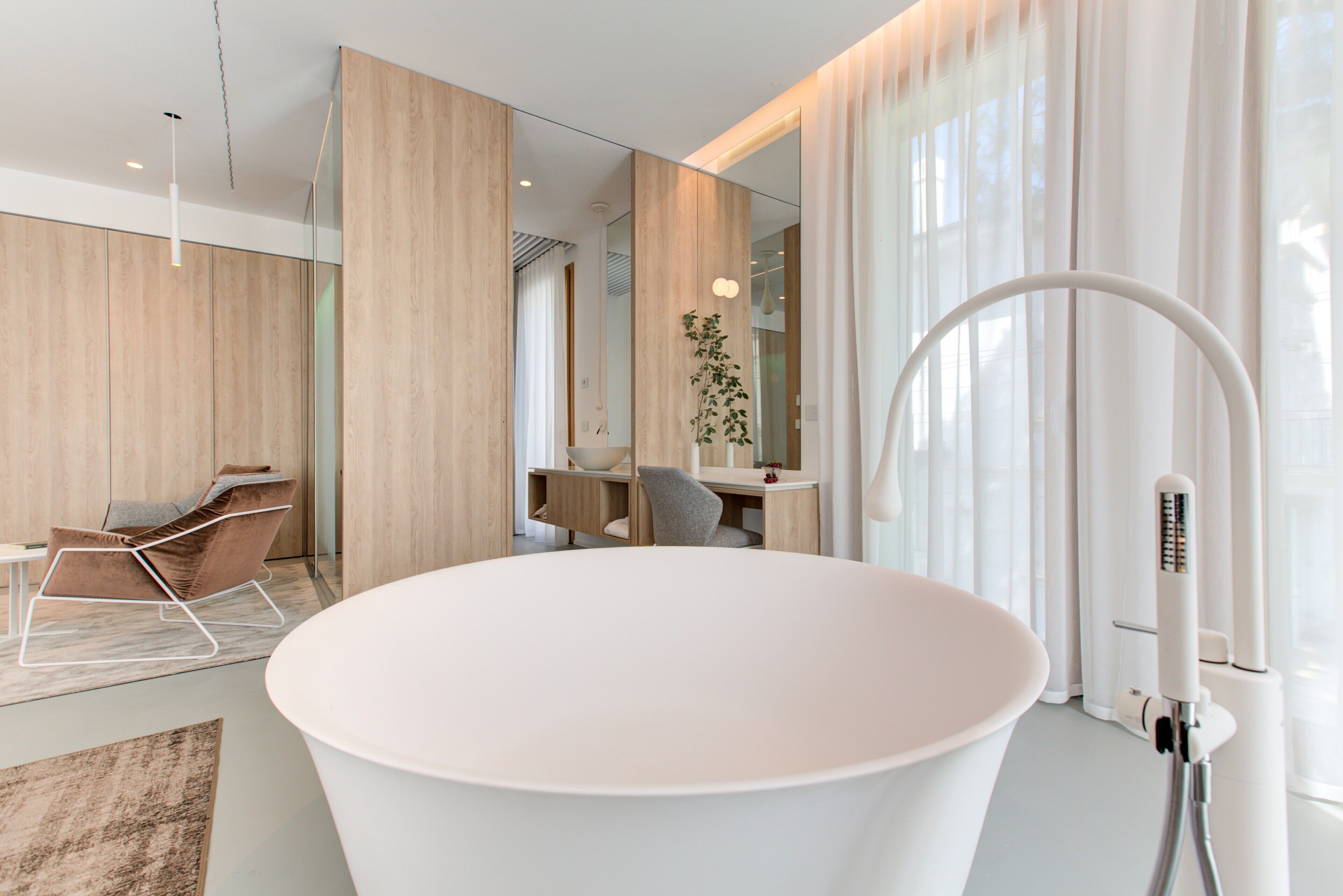 Un bagno moderno con una grande vasca da bagno bianca, una seduta elegante e un design minimalista.