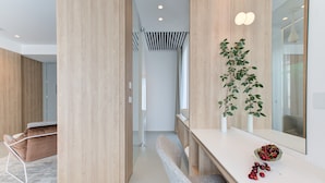 Un interior moderno con una pared de acento de madera, una encimera blanca con un cuenco de cerezas y una planta en maceta.