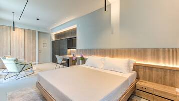 A modern bedroom with a large bed, a desk, and a chair.