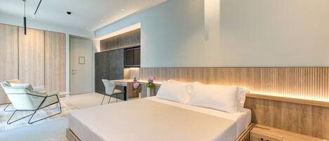 Une chambre à coucher moderne avec un grand lit, un bureau et une chaise.