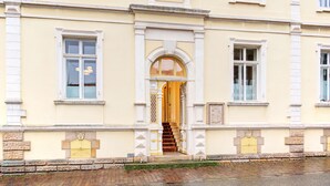 A building with a central entrance, multiple windows, and stone steps leading to the entrance. - Wohnung in Historischem Herrenhaus (Rhodt unter Rietburg)