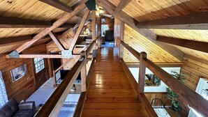 Un intérieur en bois, avec un plafond haut et une structure centrale en poutres de bois.