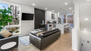 Un appartement moderne comprenant un salon, une cuisine et un coin repas.