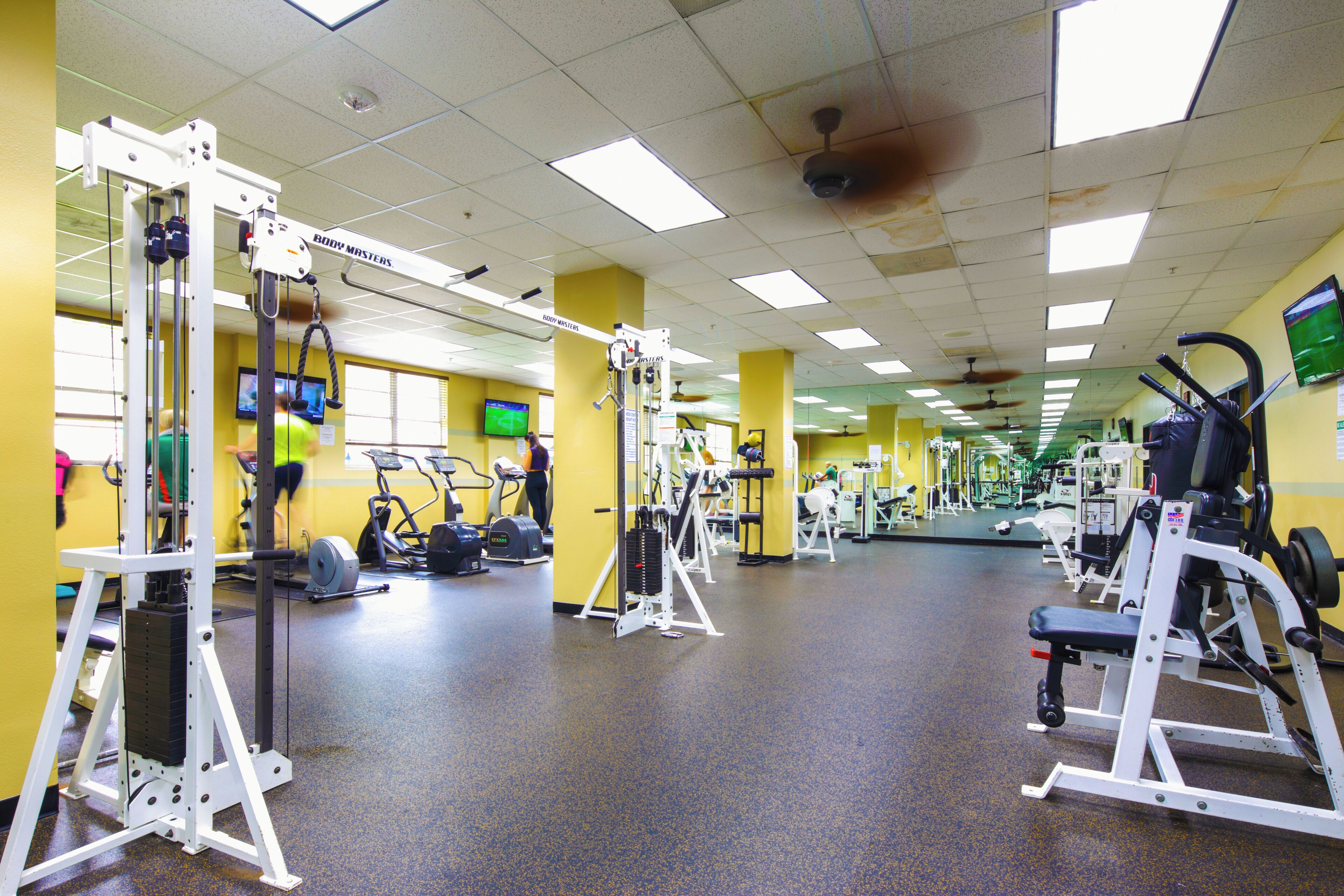 A gym with various exercise equipment, including treadmills and weight machines.