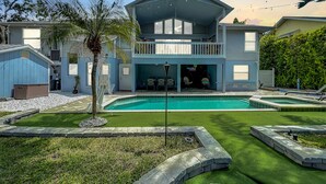 A two-story house with a swimming pool, a covered patio, and a sign that reads "Florida Vibes."