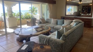 Un salon spacieux avec un grand canapé, une table basse et un coin repas.