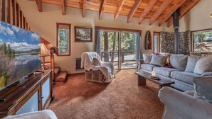 A cozy living room with a fireplace, a television, and a stone wall.