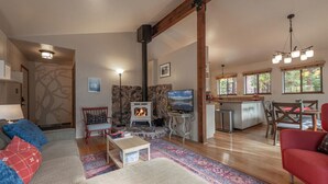 Un salon confortable avec une cheminée, un téléviseur et un coin repas.