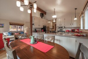Enjoy meals together at the dining table for four, surrounded by a comfortable seating area and a kitchen with modern appliances.