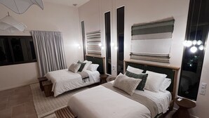 Ein modernes Hotelzimmer mit zwei Betten, einem großen Fenster und Blick auf die Stadt.