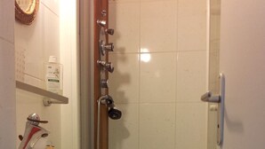 A bathroom with a shower, a sink, and a mirror.