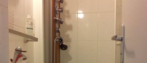 A bathroom with a shower, a sink, and a mirror.
