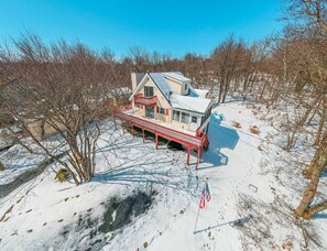 Een huis met een rood balkon en een sneeuwbedekt dak.