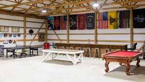 Une salle de billard équipée d’une table de billard américain, d’une table de billard français et d’un bar.